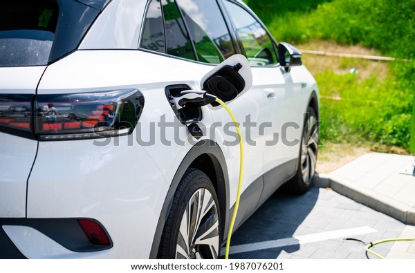 Electric Car on a\
charging station with back and light plug detail, electric\
mobility. Charging modern electric car battery on the street which\
are the future of the\
Automobile