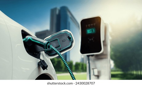 Electric car plug in with charging station to recharge battery with electricity by EV charger cable in eco green city park. Future innovative EV car using alternative clean energy reducing CO2. Peruse - Powered by Shutterstock