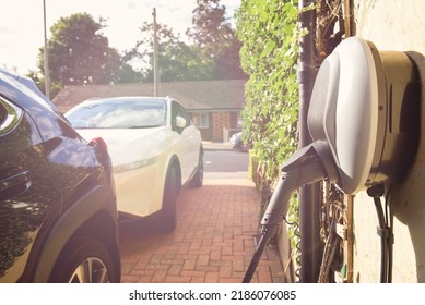 Electric Car Plugged In To Charge Outside Home With Power Cable