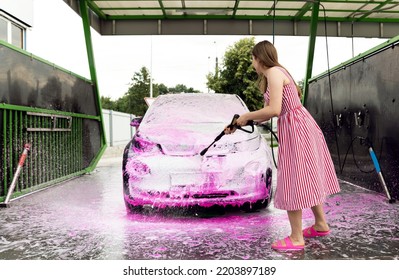 Electric Car At A Self-service  Wash. Pink Car Wash. Clean. Electric Car Cleaning. Average Washing Equipment. Service