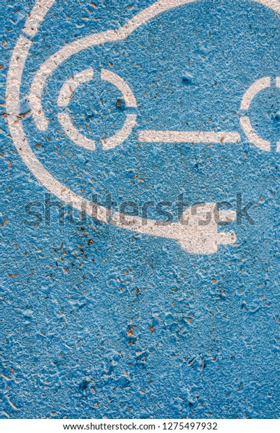 Electric cars. Sign painted on the\
floor of a parking lot for electric recharging\
station.