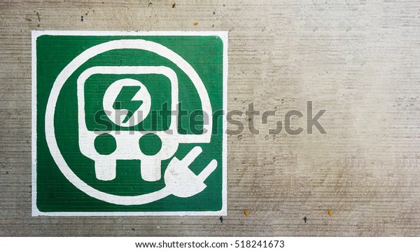 electric charge car and auto transport logo in\
concrete road floor
