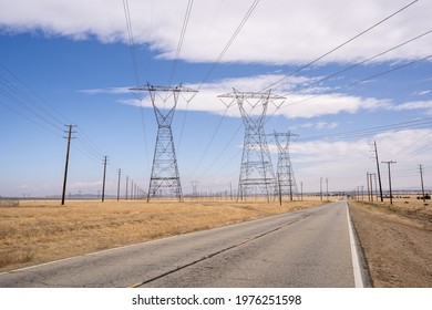 Electric Company Power Lines with Blue Sky and Clouds Long Empty Road in Palmdale California