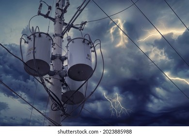 An Electric Concrete Pole, With Stormy Weather In The Background. Hazardous Potential Lightning Strike On A Transformer.