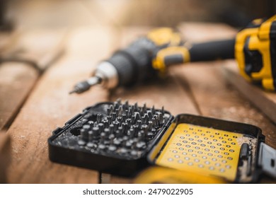 Electric cordless screwdriver. Screwdriver with spare attachments. Iron screw, screws as a background, wood screw, concept industry.