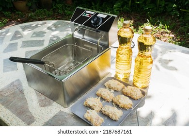 Electric Deep Fryer With Ingredients For Making Tonkatsu Stuffed With Cheese.