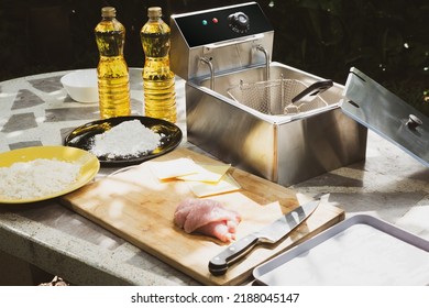 Electric Deep Fryer With Ingredients For Making Tonkatsu Stuffed With Cheese.