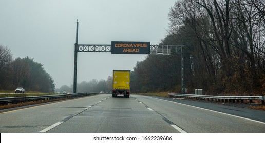 Electric Digital Warning Sign Above A Truck On A Highway That Says Coronavirus Ahead