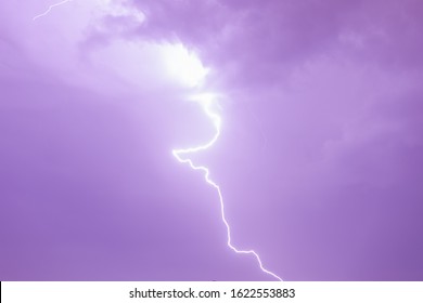 Electric discharge from a stormy sky with staccato lightning activity. Sky in purple (magenta) color. 庫存照片