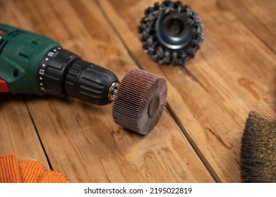 Electric drill, flap wheel, knot bowl wire disk, metal brush against the wooden background. Electric and hand tools for woodworking. Indoors. Selective focus. - Shutterstock ID 2195022819