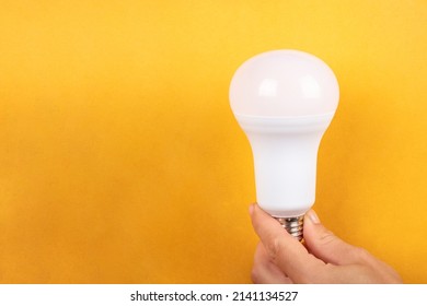 electric energy saving led lamp on yellow background with copyspace. - Shutterstock ID 2141134527