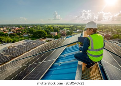 Electric Engineer Working White Safety On Height Building, Installing Solar Panels On The Rooftop Working Using Notebook Computer, Inspecting, Measuring, Collecting Data For Repairing