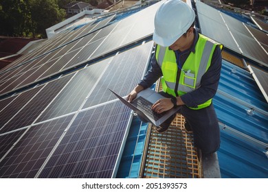 Electric Engineer Working White Safety On Height Building, Installing Solar Panels On The Rooftop Working Using Notebook Computer, Inspecting, Measuring, Collecting Data For Repairing