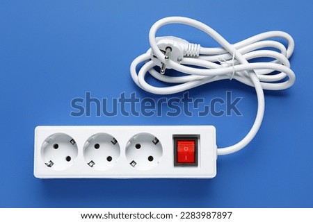 Electric extension cord on blue background