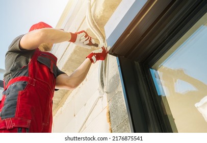 Electric Exterior Window Roller Shutters Installation Performed By Professional Caucasian Shutters Technician.