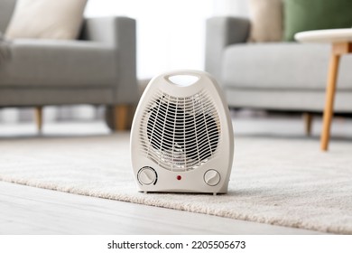 Calentador de ventilador eléctrico sobre alfombras en la sala de estar