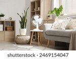 Electric fan on table in living room interior