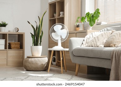 Electric fan on table in living room interior