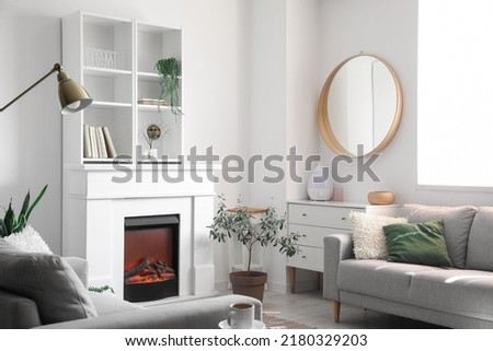 Electric fireplace and shelving unit in interior of light living room