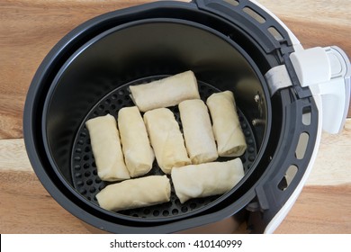 Electric Fryer With Basket Of Frozen Spring Rolls