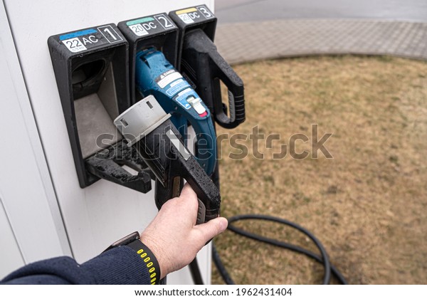 Electric gas station for electric\
vehicles. The man takes the contact wire to connect the\
machine.