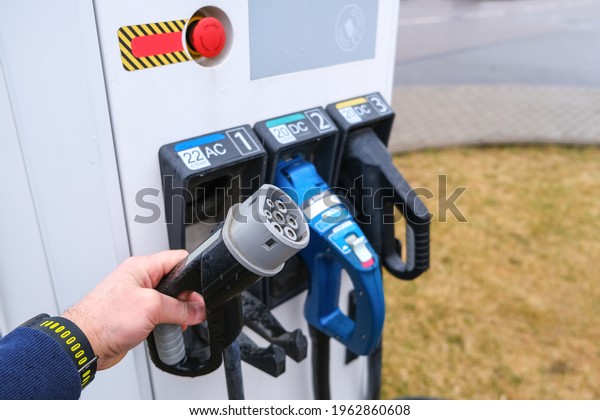 Electric gas station for electric\
vehicles. The man takes the contact wire to connect the\
machine