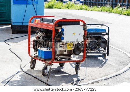 Electric generators on a city street. Portable, gasoline-powered devices for backup power supply during power outages in apartment buildings and private buildings. Close-up