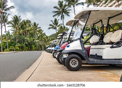 Electric golf - passenger buggies cars parked in row in Hamilton Island, Australia.