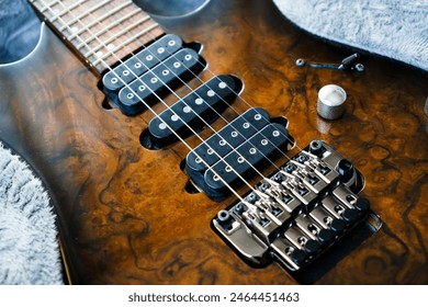 Electric guitar bridge, strings and pickup, detail close-up view of guitar pickup in wood walnut, stringed musical instrument - Powered by Shutterstock