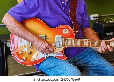 Electric Guitar Close-Up with Musician's Hands and Sunburst Finish - Powered by Shutterstock