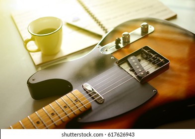  Electric guitar and  a cup of coffee on wood background