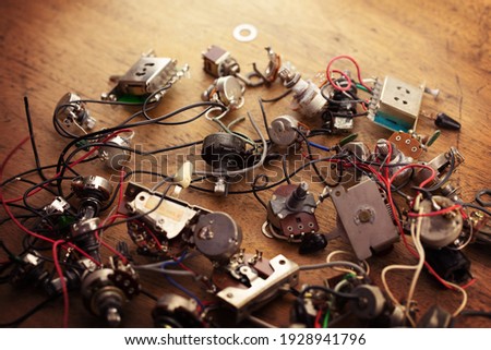Electric guitar electronic parts, scattered on a old work bench. Guitar wiring components.