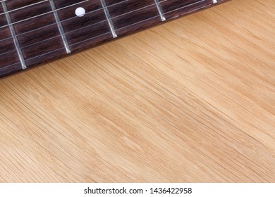 An electric guitar fretboard on a table.