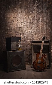 Electric Guitar And Old Amplifier On A Grunge Wall Background 