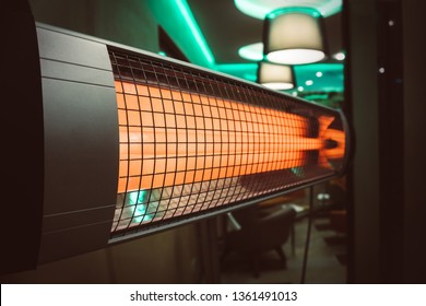 The Electric Heater In The Room. Heating The Apartment In Cold Weather. Halogen Or Infrared Heater Isolated On A White Background