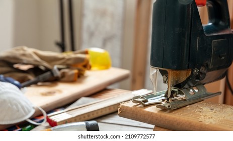 Electric Jigsaw Cutting Wood. Construction Industry, Carpenter Workshop, Work Bench Table Closeup View