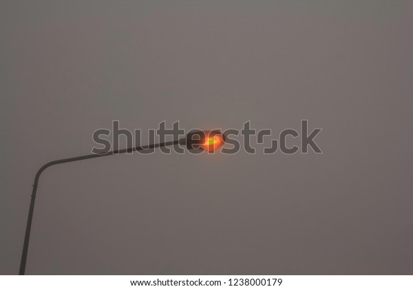 \
Electric lamps and electric poles\
in the rainy and stormy winter The fog is very thick, almost\
invisible, except for the electric pole and the gray sky\
background.
