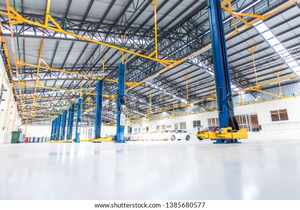 The electric lift for cars in the service put\
on the epoxy floor in new car factory service , Car repair service\
center   background for industry\
