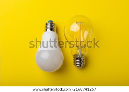 Electric light bulbs. the concept of energy efficiency. LED lamp vs incandescent lamp. Composition on a yellow background. Use an economical and environmentally friendly light bulb concept.