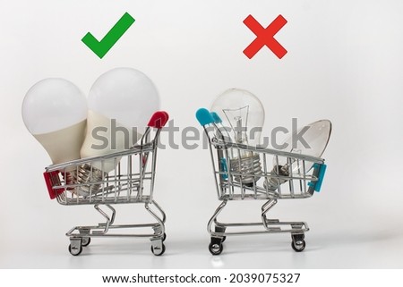 electric light bulbs in shopping baskets. the concept of energy efficiency. led lamps versus incandescent lamps. on a white background