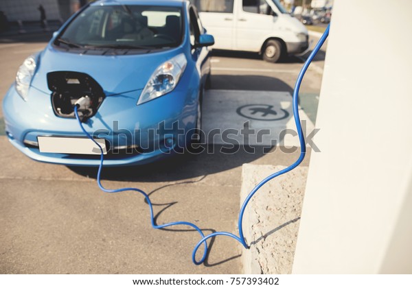 The\
electric machine stopped at the charging station to recharge. The\
cable leads from the connector to the\
electrician.