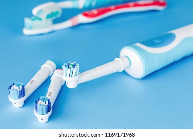 Electric and manual toothbrush  on blue background, close up