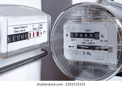 Electric meter and natural gas meter at apartment. Utility bills, cost of living, consumption of electricity and gas for heating home, energy costs, symbolic image. - Shutterstock ID 2331115155