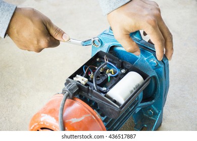 Electric Motor  And Man Working Equipment Repair On Cement Floor Background.Background Motor Or Equipment.Zoom In