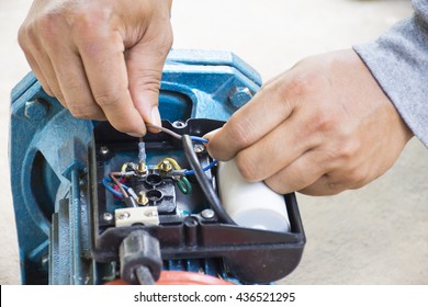 Electric Motor  And Man Working Equipment Repair On Cement Floor Background.Background Motor Or Equipment.Close Up.