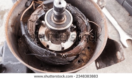 Electric motor windings that have caught fire due to being overloaded so that it overheats. Burnt electric motor windings.