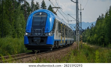 Electric Multiple Unit train Pesa Elf II 27WEb-006F running on a rural railway track in Poland