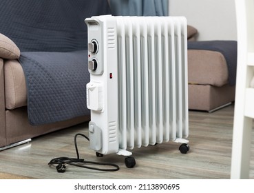 Electric Oil-filled Radiator For Heating Home And Maintain Comfortable Temperature Standing In Cozy Living Room