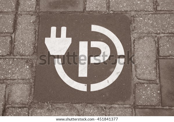 Electric Parking Site Symbol in Urban Setting in\
Black and White Sepia\
Tone