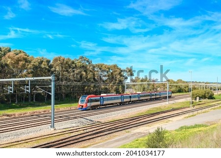 Electric passenger train departing from the Mile End Railway Station and heading to Adelaide city on a bright day